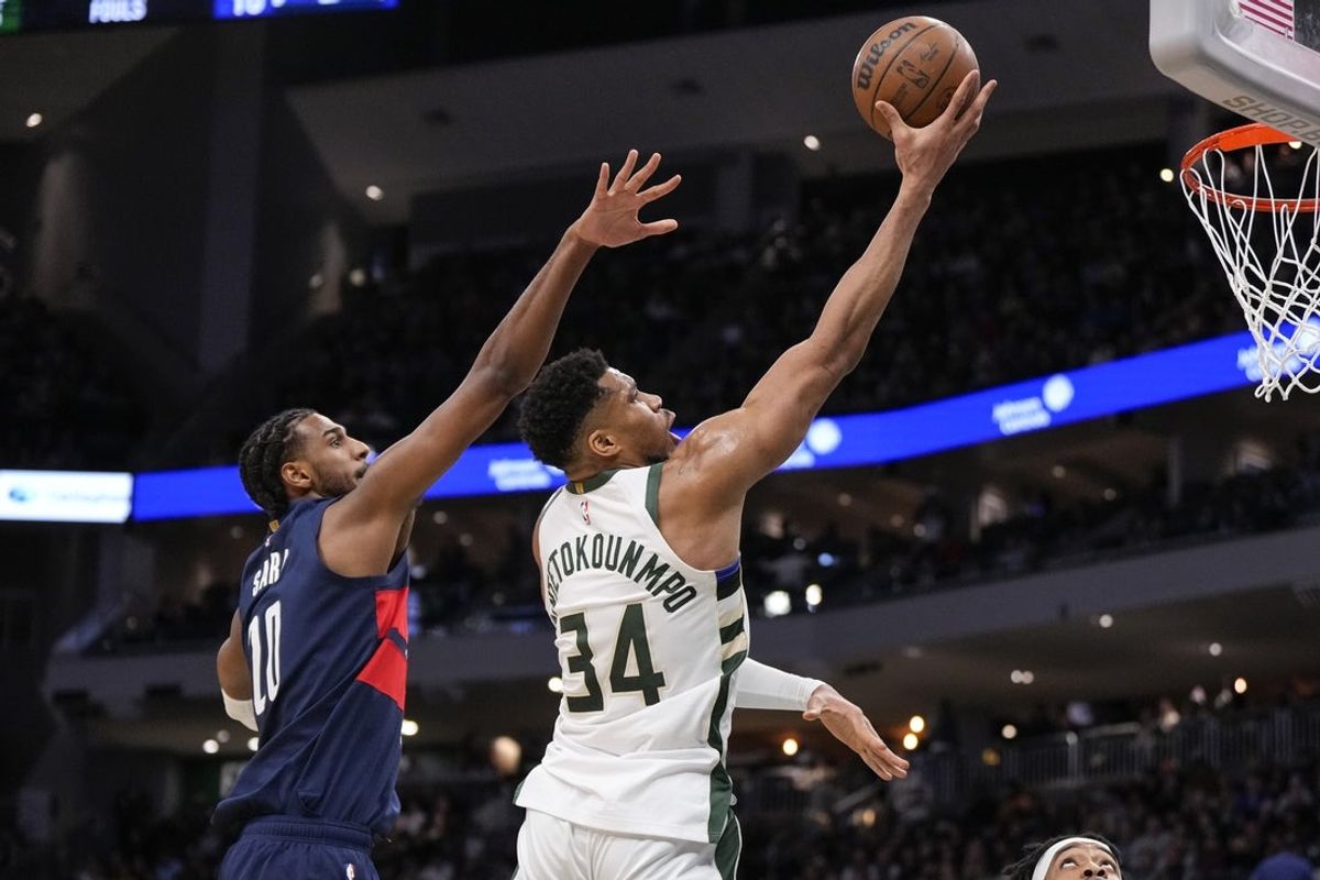 Dec 31, 2025; Milwaukee, Wisconsin, USA;  Milwaukee Bucks forward Giannis Antetokounmpo (34) shoots in front of Washington Wizards forward Alexandre Sarr (20) during the second quarter at Fiserv Forum. Mandatory Credit: Jeff Hanisch-Imagn Images