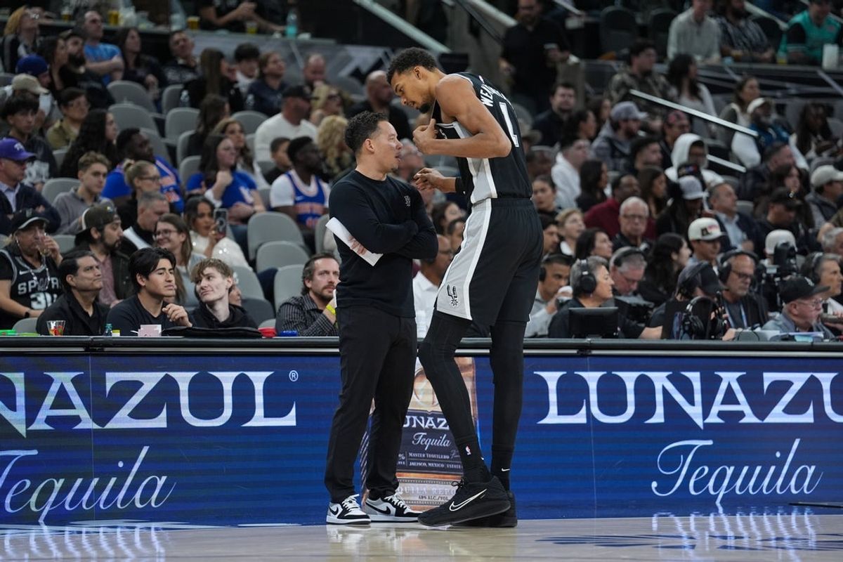 Dec 31, 2025; San Antonio, Texas, USA;  San Antonio Spurs head coach Mitch Johnson talks with forward Victor Wembanyama (1) in the second half against the New York Knicks at Frost Bank Center. Mandatory Credit: Daniel Dunn-Imagn Images