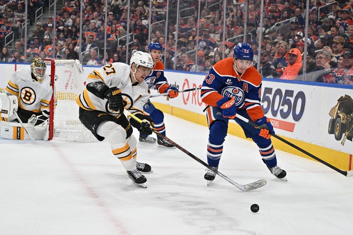 Dec 31, 2025; Edmonton, Alberta, CAN;  Boston Bruins defenseman Hampus Lindholm (27) battles for the puck with Edmonton Oilers center Ryan Nugent-Hopkins (93) during the first period at Rogers Place. Mandatory Credit: Walter Tychnowicz-Imagn Images