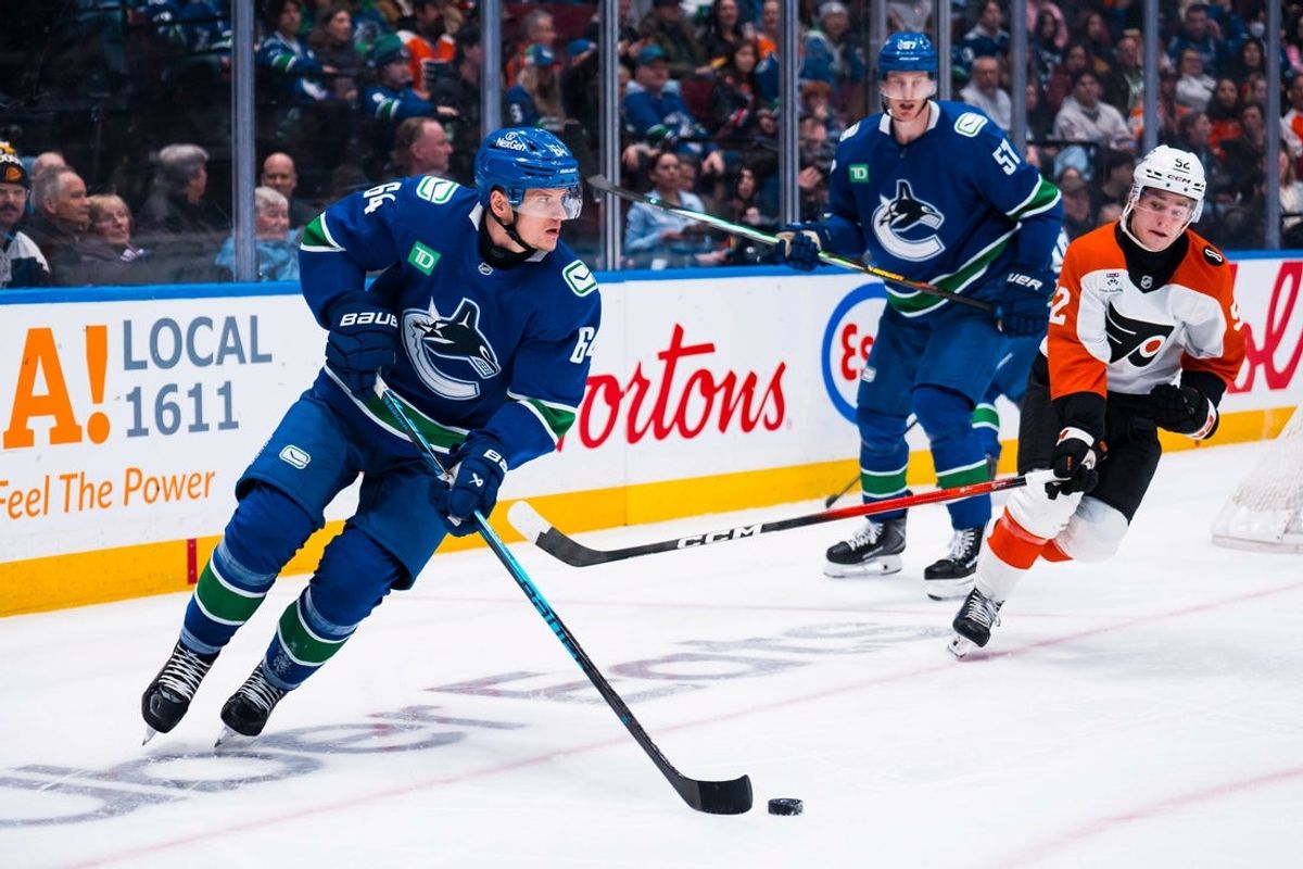 Dec 30, 2025; Vancouver, British Columbia, CAN; Vancouver Canucks forward David Kampf (64) handles the puck against the Philadelphia Flyers in the third period at Rogers Arena. Mandatory Credit: Bob Frid-Imagn Images