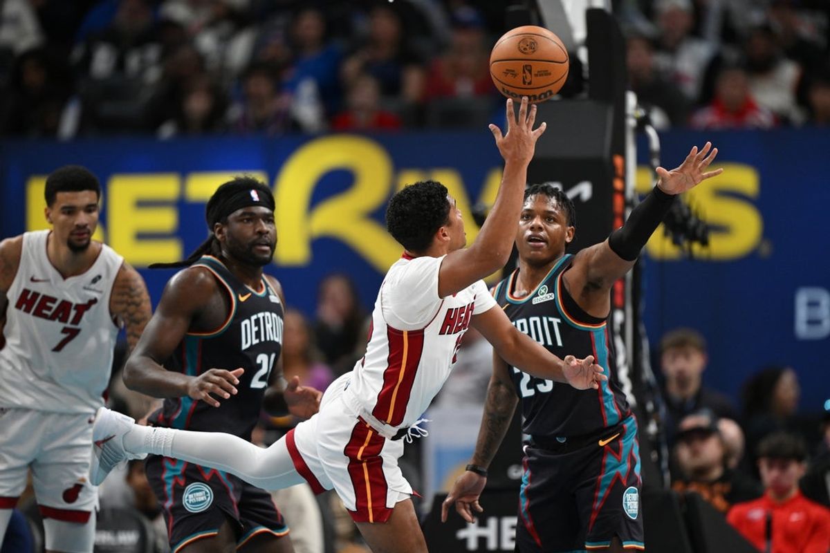 Jan 1, 2026; Detroit, Michigan, USA; Miami Heat guard Dru Smith (12) puts up an off balance shot over Detroit Pistons guard Marcus Sasser (25) in the first quarter at Little Caesars Arena. Mandatory Credit: Lon Horwedel-Imagn Images
