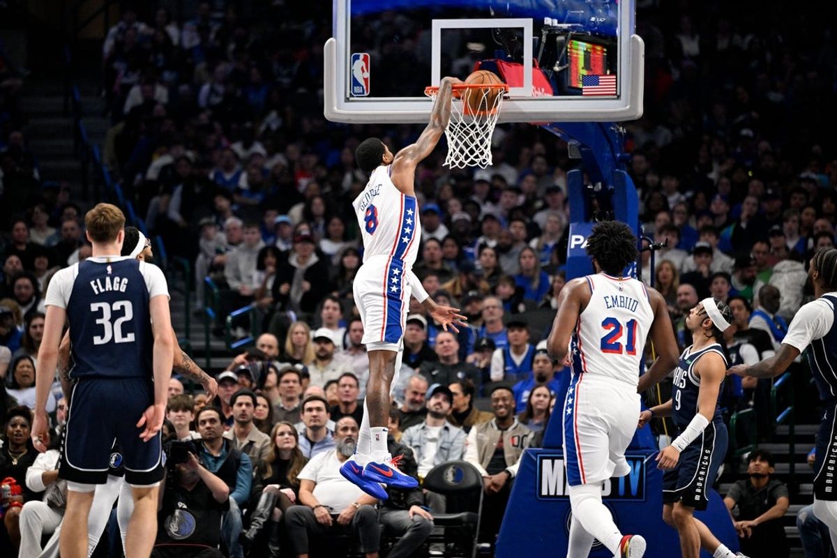 Jan 1, 2026; Dallas, Texas, USA; Philadelphia 76ers forward Paul George (8) dunks the ball past Dallas Mavericks forward Cooper Flagg (32) during the second quarter at the American Airlines Center. Mandatory Credit: Jerome Miron-Imagn Images