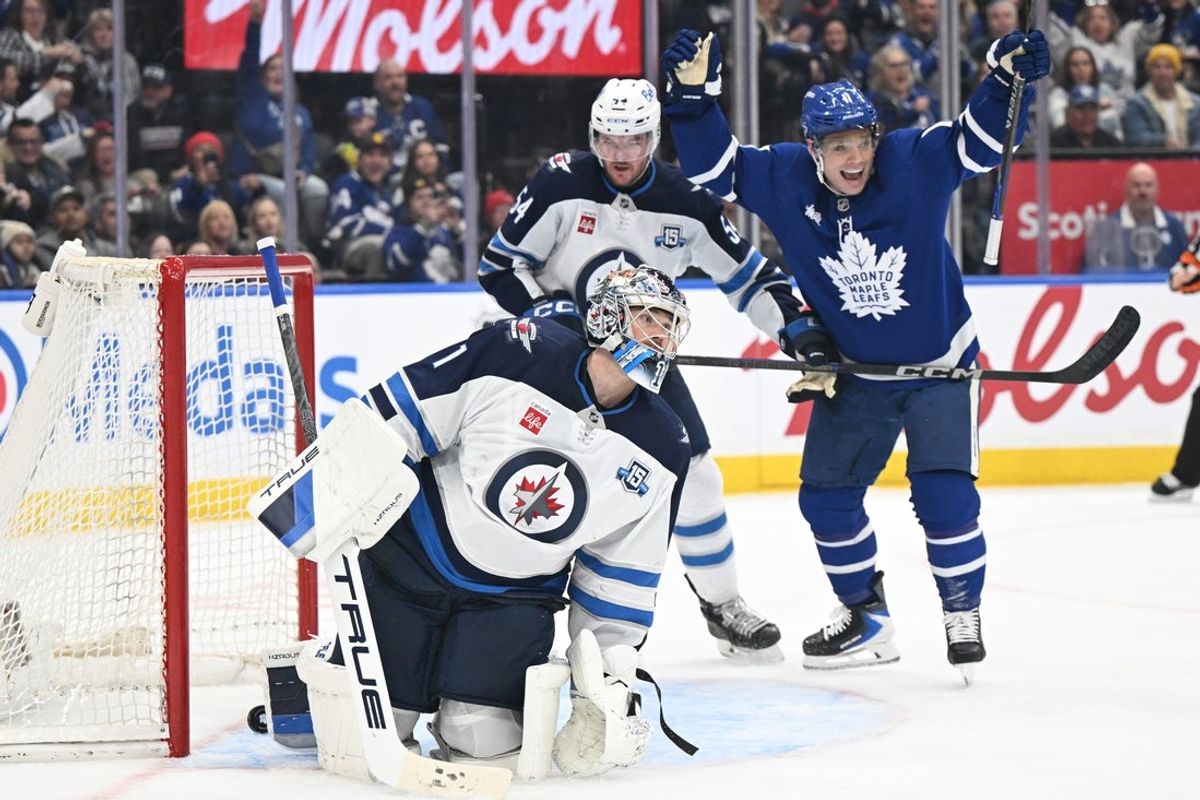 Jan 1, 2026; Toronto, Ontario, CAN;  Winnipeg Jets goalie Eric Comrie (1) reacts after being scored on by Toronto Maple Leafs defenseman Troy Stecher (not shown) as Maple Leafs forward Max Domi (11) celebrates in the third period at Scotiabank Arena. Mandatory Credit: Dan Hamilton-Imagn Images