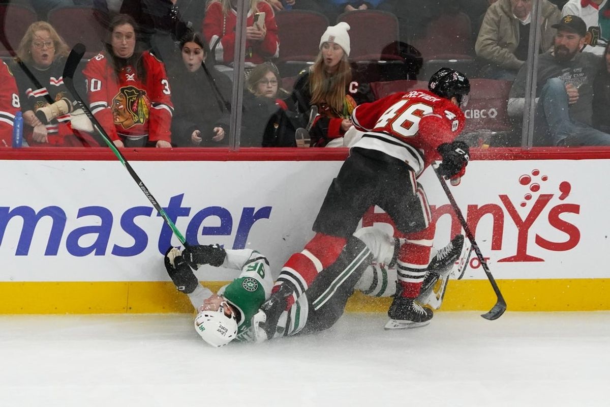 Jan 1, 2026; Chicago, Illinois, USA; Chicago Blackhawks defenseman Louis Crevier (46) checks Dallas Stars right wing Mikko Rantanen (96) during the third period at United Center. Mandatory Credit: David Banks-Imagn Images