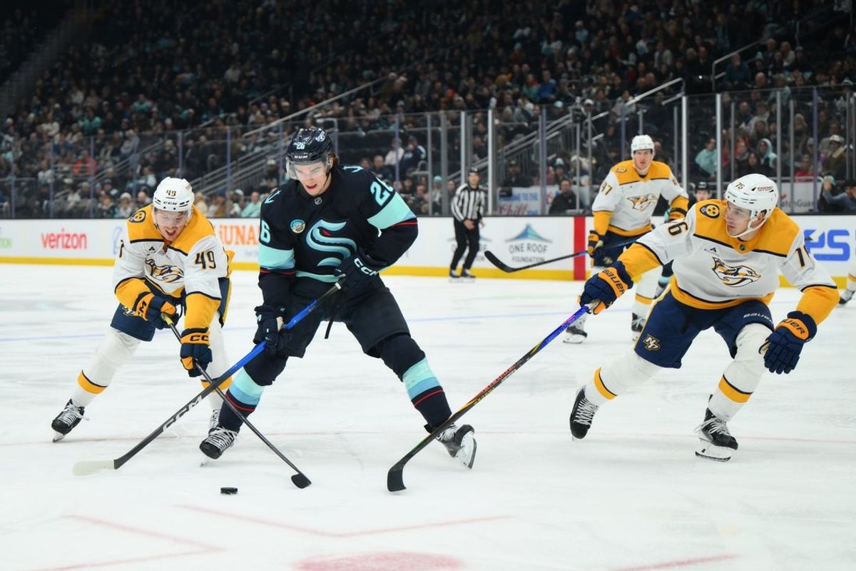 Jan 1, 2026; Seattle, Washington, USA; Nashville Predators left wing Reid Schaefer (49) steals the puck from Seattle Kraken center Ryan Winterton (26) during the second period at Climate Pledge Arena. Mandatory Credit: Steven Bisig-Imagn Images