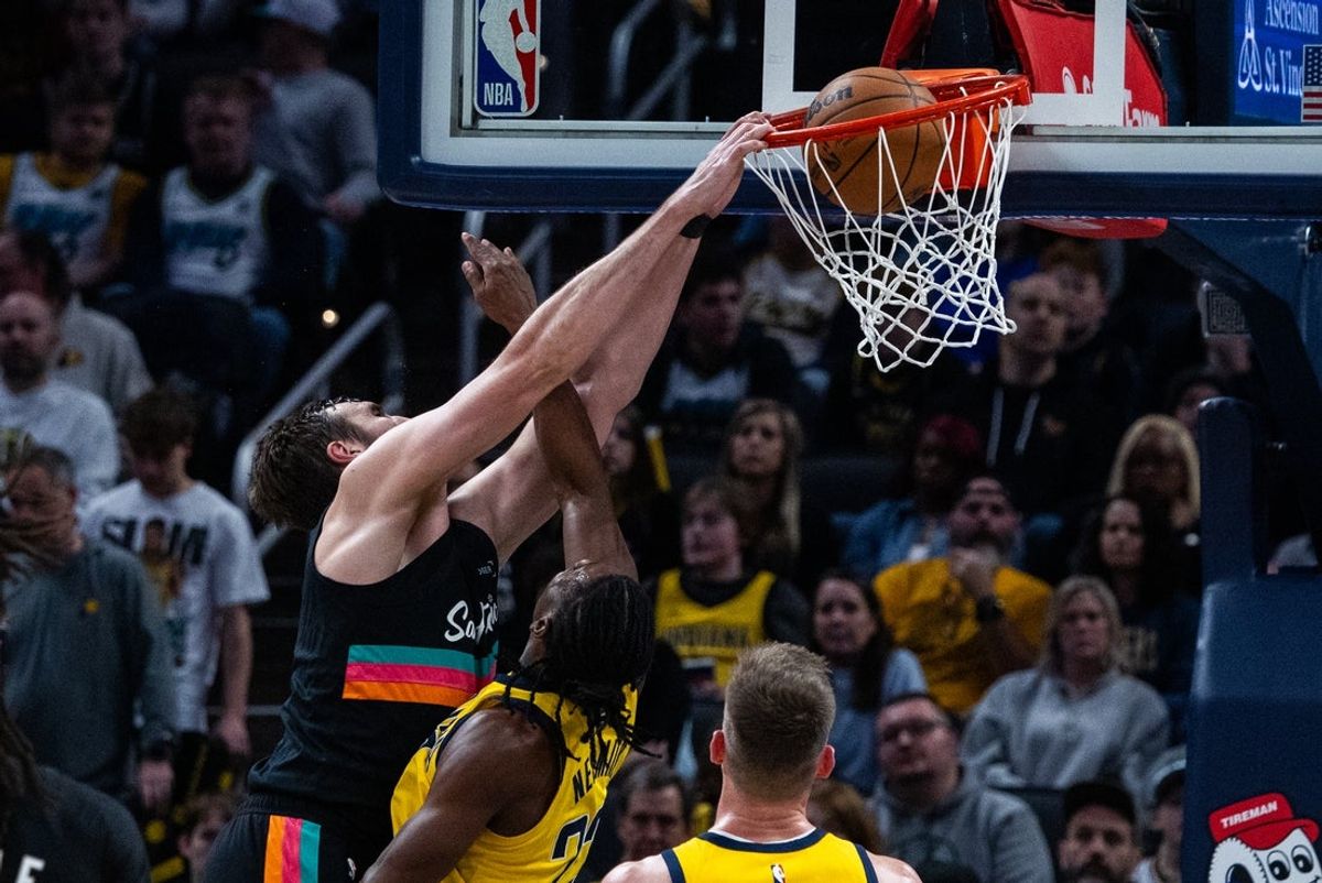 Jan 2, 2026; Indianapolis, Indiana, USA;  San Antonio Spurs center/forward Luke Kornet (7) shoots the ball while  Indiana Pacers guard/forward Aaron Nesmith (23) defends in the first half at Gainbridge Fieldhouse. Mandatory Credit: Trevor Ruszkowski-Imagn Images