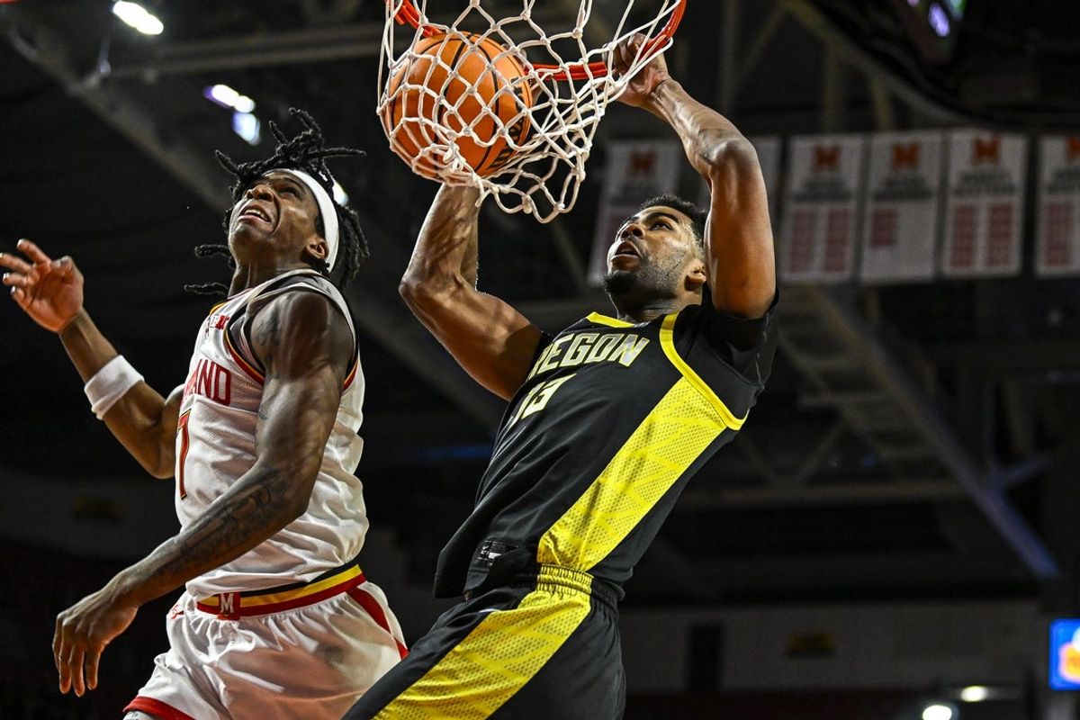 Jan 2, 2026; College Park, Maryland, USA;  Oregon Ducks forward Sean Stewart (13) dunks on Maryland Terrapins guard Andre Mills (7) during the first half at Xfinity Center. Mandatory Credit: Tommy Gilligan-Imagn Images