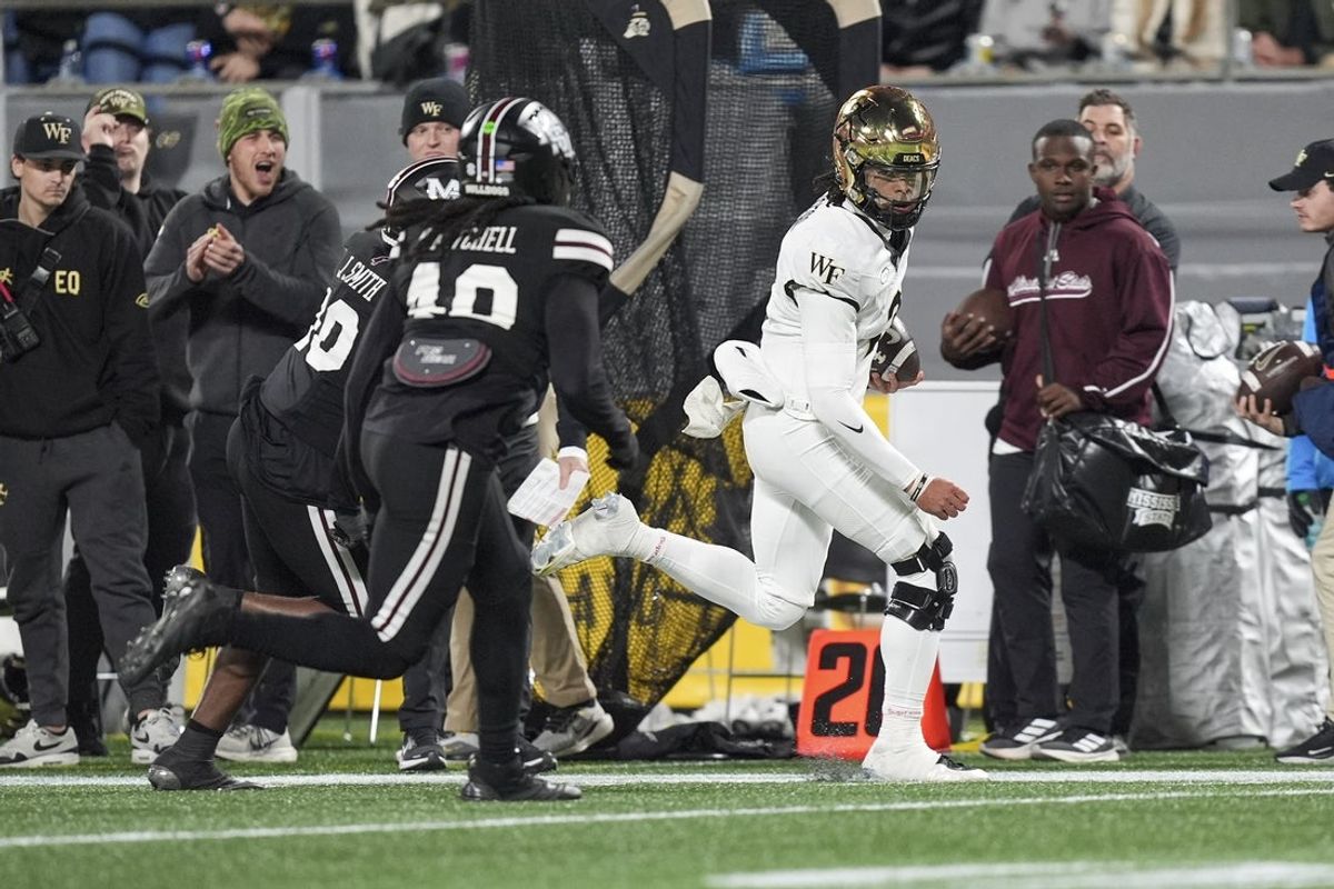 Jan 2, 2026; Charlotte, NC, USA; Wake Forest Demon Deacons quarterback Robby Ashford (2) runs a keeper chased by Mississippi State Bulldogs linebacker Turner Reeves (48) during the first quarter at Bank of America Stadium. Mandatory Credit: Jim Dedmon-Imagn Images