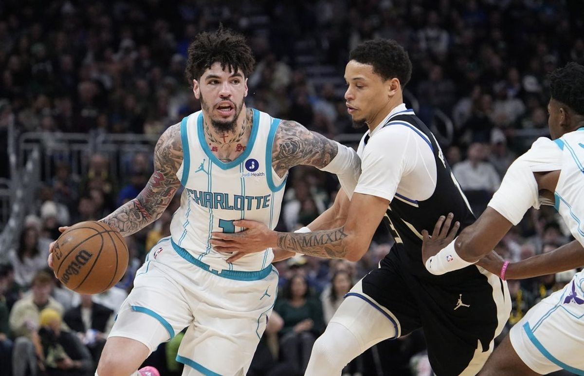 Jan 2, 2026; Milwaukee, Wisconsin, USA; Charlotte Hornets guard Lamelo Ball (1) drives against Milwaukee Bucks guard Ryan Rollins (13) in the first half at Fiserv Forum. Mandatory Credit: Michael McLoone-Imagn Images