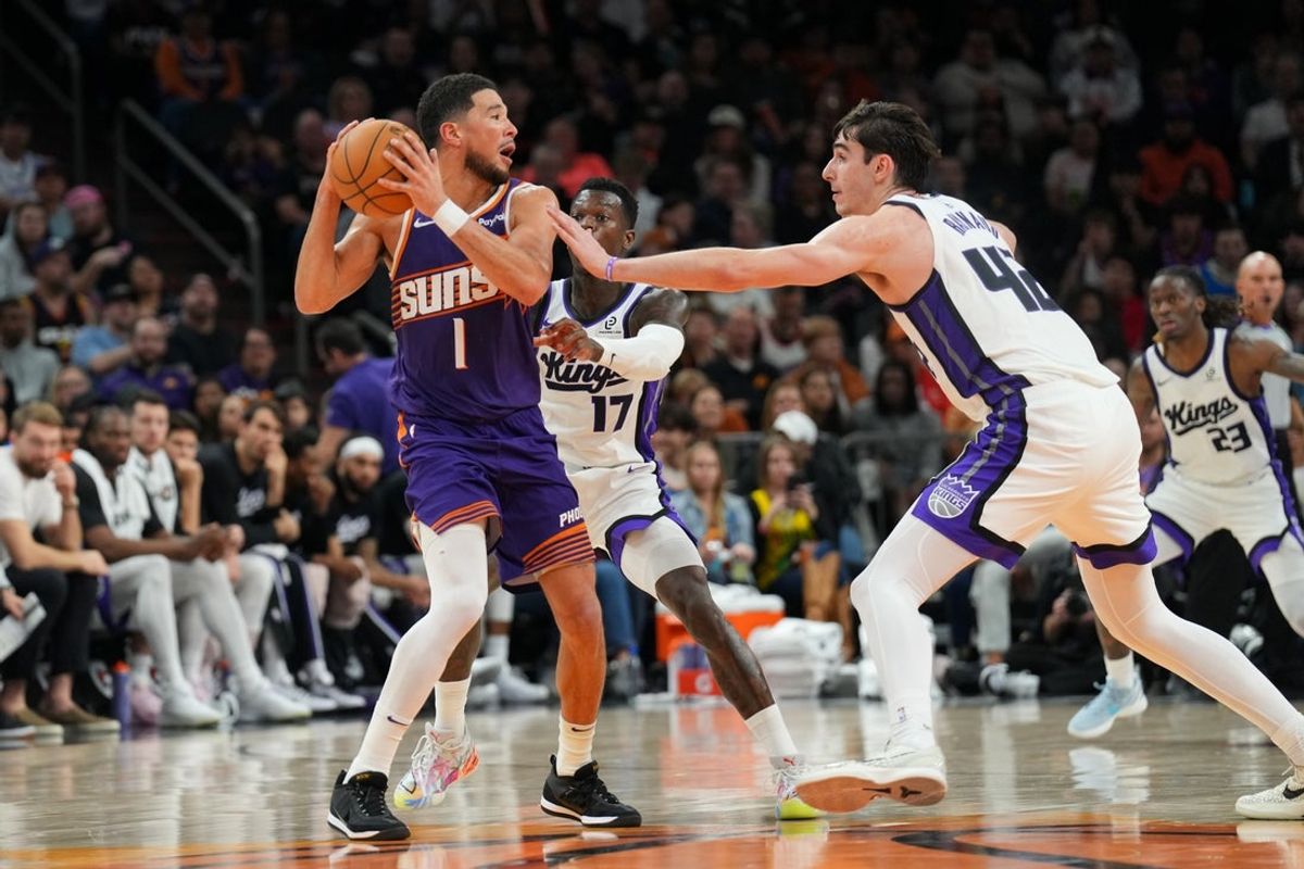 Jan 2, 2026; Phoenix, Arizona, USA; Sacramento Kings center Maxime Raynaud (42) and Sacramento Kings guard Dennis Schroder (17) guard  Phoenix Suns guard Devin Booker (1) during the second half at Mortgage Matchup Center. Mandatory Credit: Joe Camporeale-Imagn Images