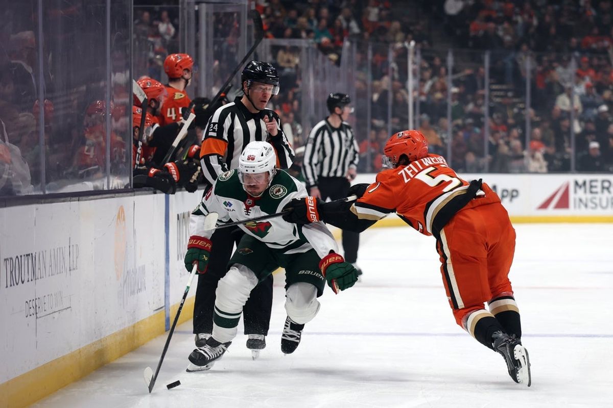 Jan 2, 2026; Anaheim, California, USA;  Minnesota Wild left wing Marcus Johansson (90) skates with the puck as Anaheim Ducks defenseman Olen Zellweger (51) defends during the first period at Honda Center. Mandatory Credit: Kiyoshi Mio-Imagn Images
