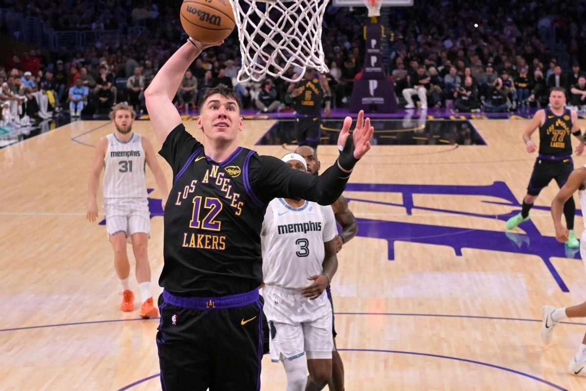 Jan 2, 2026; Los Angeles, California, USA;Los Angeles Lakers forward Jake Laravia (12) goes up for a dunk during the first half against the Memphis Grizzlies at Crypto.com Arena. Mandatory Credit: Jayne Kamin-Oncea-Imagn Images
