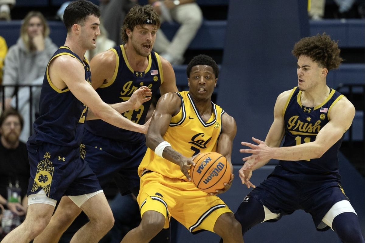 Jan 2, 2026; Berkeley, California, USA; California Golden Bears guard Dai Dai Ames (7) grabs an offensive rebound before a trio of Notre Dame Fighting Irish defenders during the first half at Haas Pavilion. Mandatory Credit: D. Ross Cameron-Imagn Images