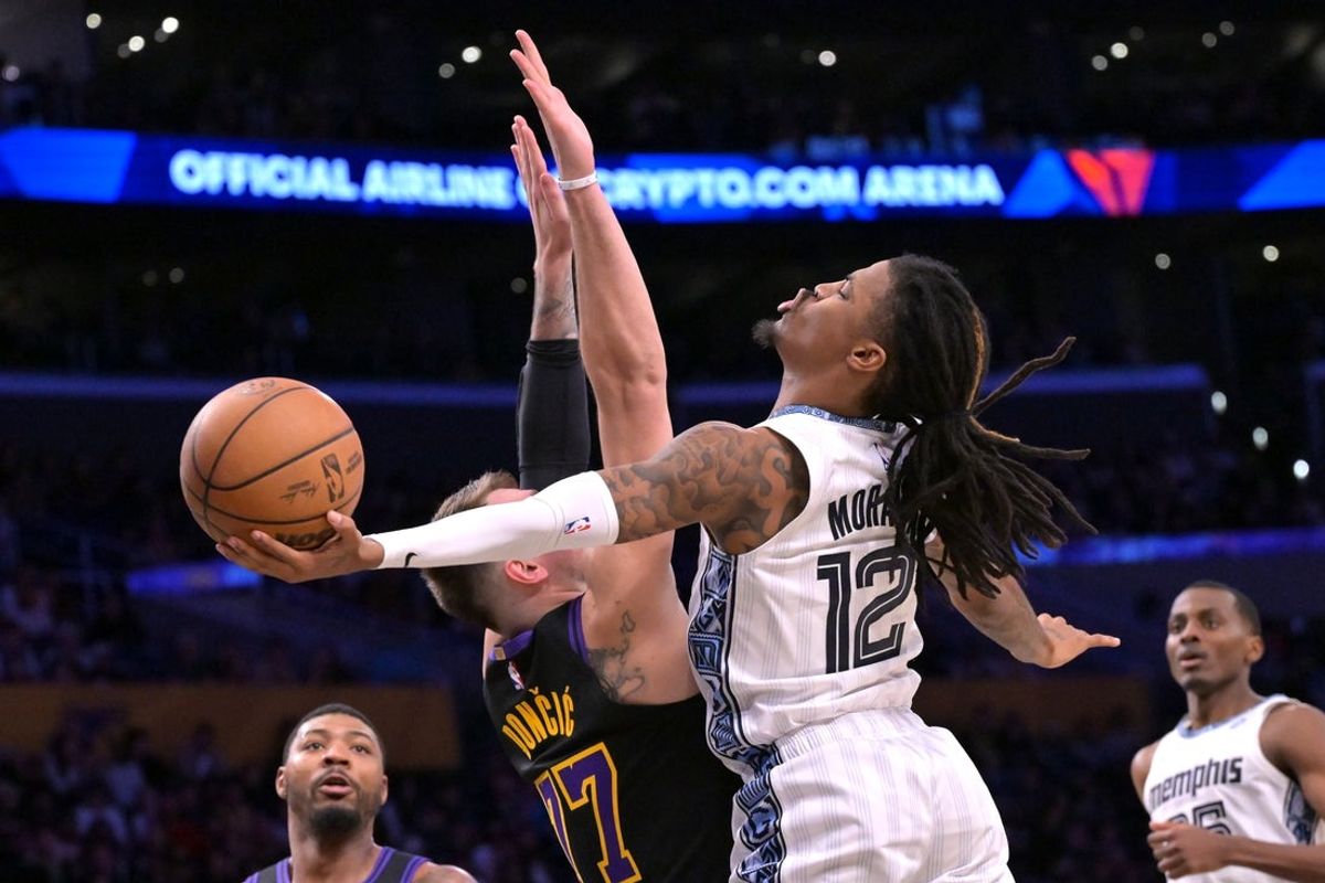 Jan 2, 2026; Los Angeles, California, USA; Los Angeles Lakers guard Luka Doncic (77) defends a shot by Memphis Grizzlies guard Ja Morant (12) in the first half at Crypto.com Arena. Mandatory Credit: Jayne Kamin-Oncea-Imagn Images