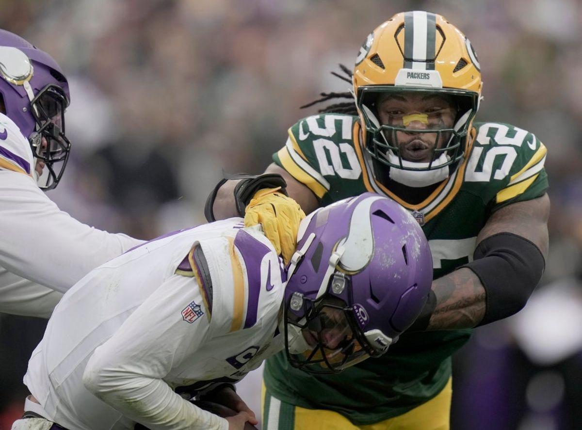 Minnesota Vikings' J.J. McCarthy (9) evades a sack by Green Bay Packers defensive end Rashan Gary (52) during the fourth quarter of their game Sunday, November 23, 2025 at Lambeau Field in Green Bay, Wisconsin. The Green Bay Packers beat the Minnesota Vikings 23-6.