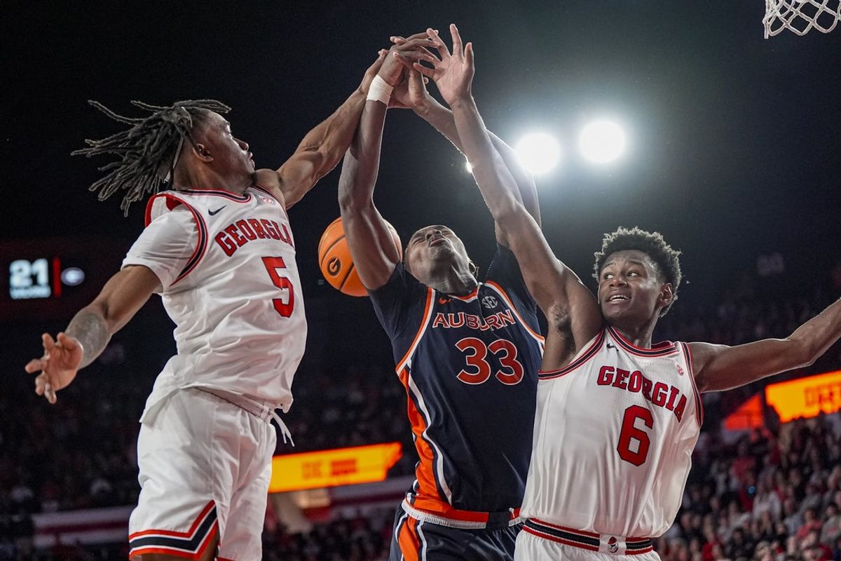 Jan 3, 2026; Athens, Georgia, USA; Georgia Bulldogs guard Jeremiah Wilkinson (5) and forward Kanon Catchings (6) fight for a rebound with Auburn Tigers forward Sebastian Williams-Adams (33) during overtime at Stegeman Coliseum. Mandatory Credit: Dale Zanine-Imagn Images