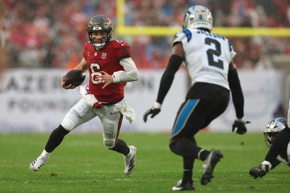 Jan 3, 2026; Tampa, Florida, USA;  Tampa Bay Buccaneers quarterback Baker Mayfield (6) runs against Carolina Panthers cornerback Mike Jackson (2) in the first half at Raymond James Stadium. Mandatory Credit: Nathan Ray Seebeck-Imagn Images