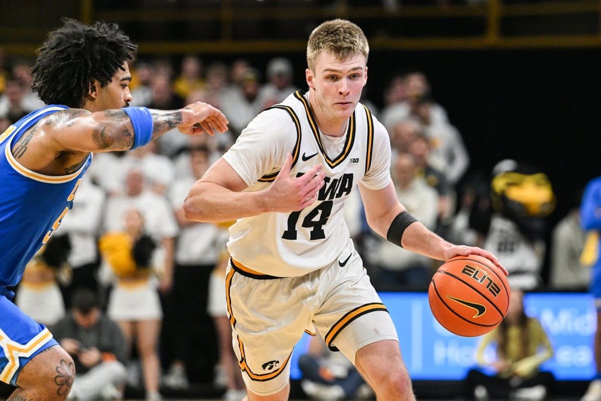 Jan 3, 2026; Iowa City, Iowa, USA; Iowa Hawkeyes guard Bennett Stirtz (14) controls the ball as UCLA Bruins guard Skyy Clark (55) defends during the second half at Carver-Hawkeye Arena. Mandatory Credit: Jeffrey Becker-Imagn Images