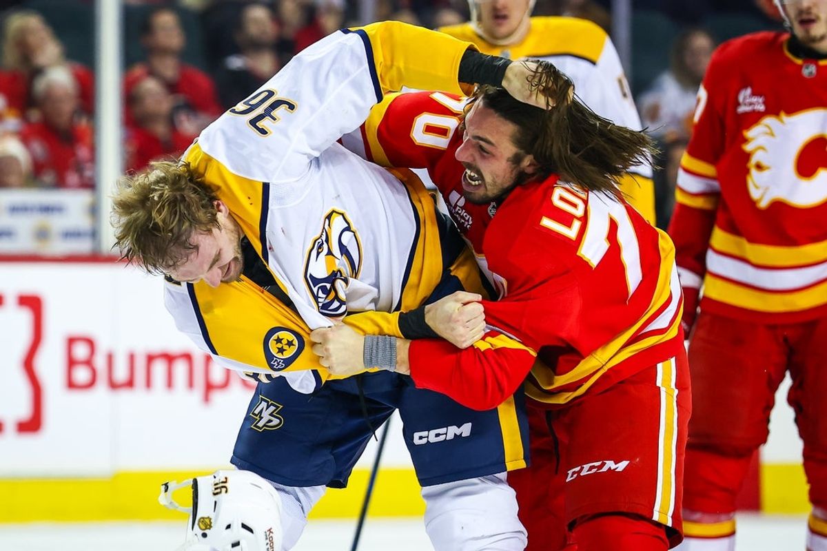 Jan 3, 2026; Calgary, Alberta, CAN; Calgary Flames left wing Ryan Lomberg (70) and Nashville Predators right wing Cole Smith (36) fight during the first period at Scotiabank Saddledome. Mandatory Credit: Sergei Belski-Imagn Images