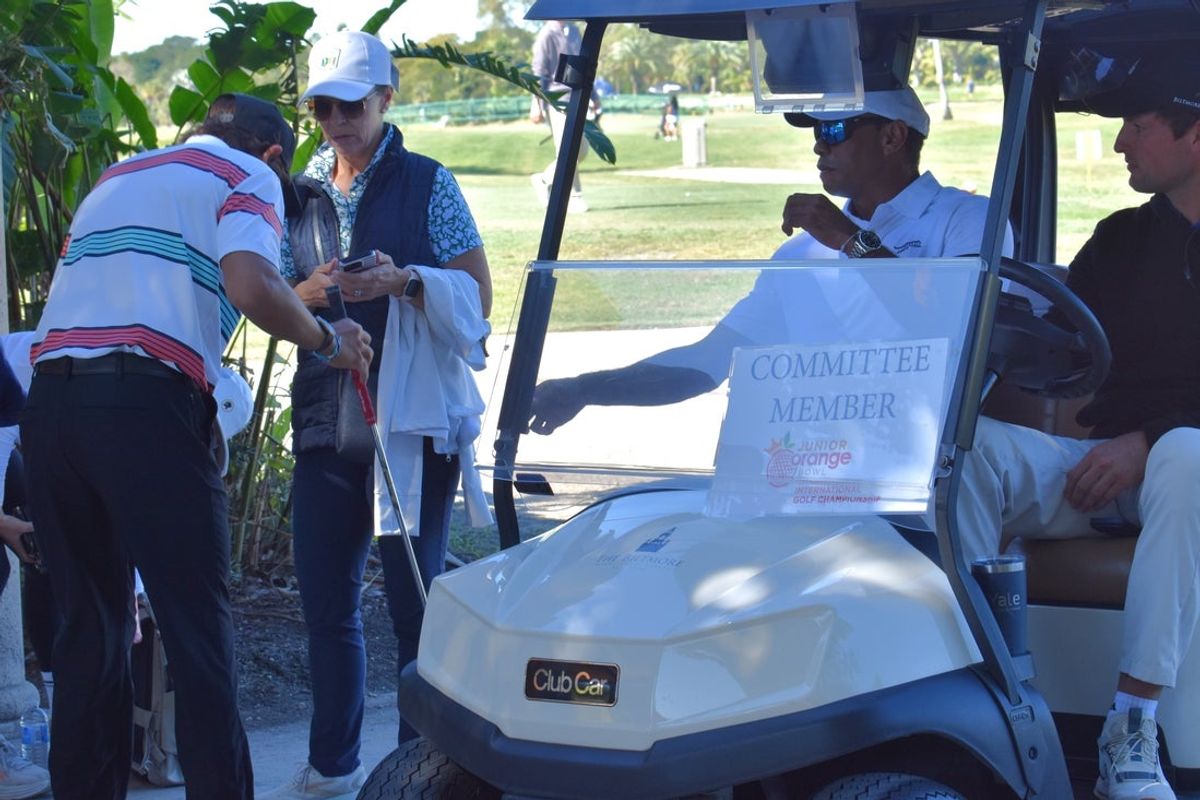 Tiger Woods reaches for son Charlie Woods' club to check it out after it takes a knock against a clump of tree roots during the Junior Orange Bowl on Jan. 3, 2026.