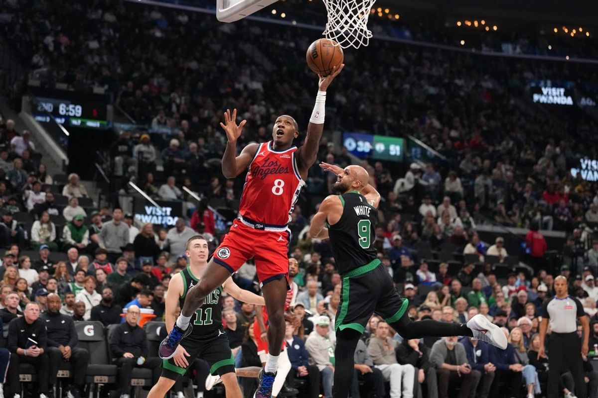 Jan 3, 2026; Inglewood, California, USA; LA Clippers guard Kris Dunn (8) shoots the ball against Boston Celtics guard Derrick White (9) n the first half at Intuit Dome. Mandatory Credit: Kirby Lee-Imagn Images