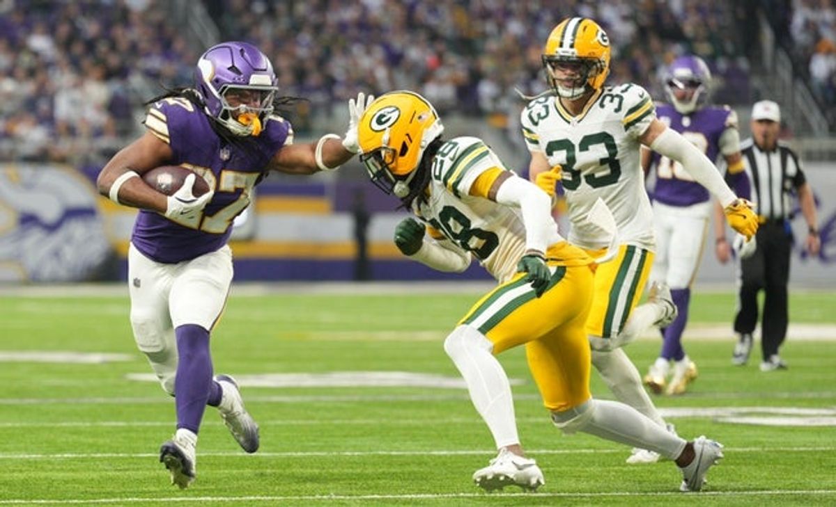 Jan 4, 2026; Minneapolis, Minnesota, USA; Minnesota Vikings running back Jordan Mason (27) runs the ball against Green Bay Packers cornerback Trevon Diggs (28) during the second quarter at U.S. Bank Stadium. Mandatory Credit: Matt Blewett-Imagn Images