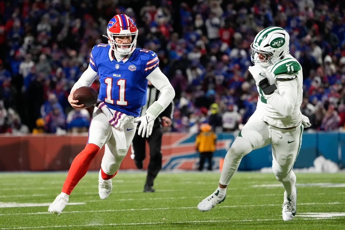 Jan 4, 2026; Orchard Park, New York, USA; Buffalo Bills quarterback Mitchell Trubisky (11) scrambles with the ball defended by New York Jets linebacker Jermaine Johnson (11) during the third quarter at Highmark Stadium. Mandatory Credit: Gregory Fisher-Imagn Images