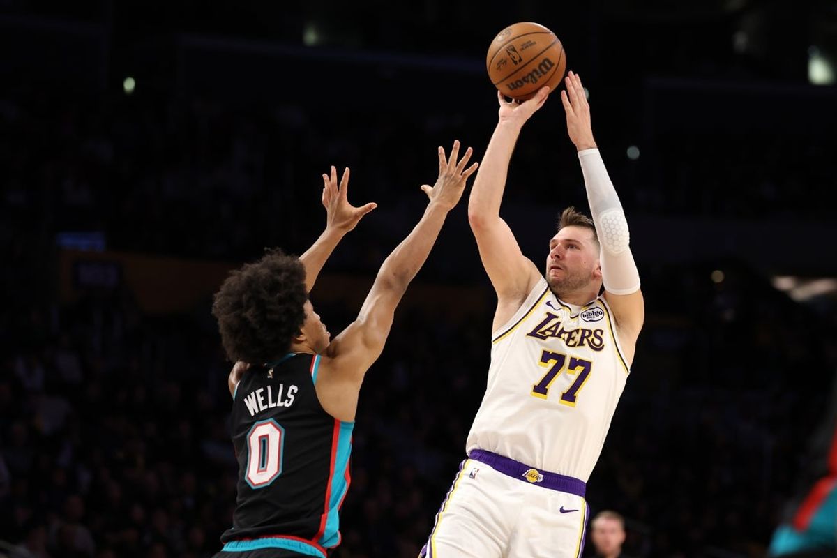 Jan 4, 2026; Los Angeles, California, USA;  Los Angeles Lakers forward/guard Luka Doncic (77) shoots the ball over Memphis Grizzlies forward Jaylen Wells (0) during the first quarter at Crypto.com Arena. Mandatory Credit: Kiyoshi Mio-Imagn Images