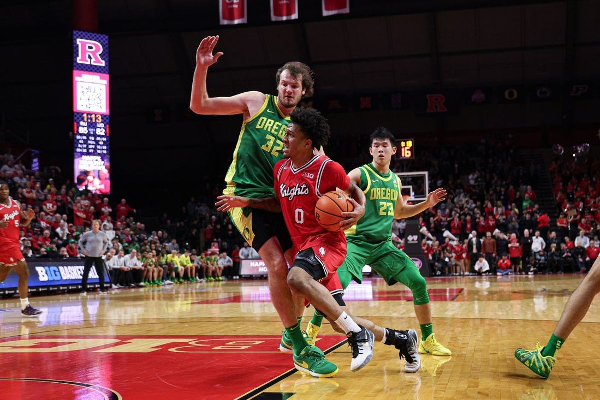 Jan 5, 2026; Piscataway, New Jersey, USA; Rutgers Scarlet Knights guard Tariq Francis (0) drives to the basket as Oregon Ducks center Nate Bittle (32) defends during overtime at Jersey Mike's Arena. Mandatory Credit: Vincent Carchietta-Imagn Images