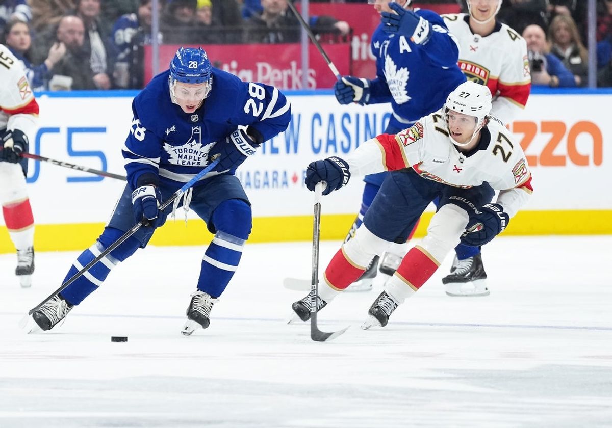 Jan 6, 2026; Toronto, Ontario, CAN; Toronto Maple Leafs defenseman Troy Stecher (28) battles for the puck with Florida Panthers center Eetu Luostarinen (27) during the second period at Scotiabank Arena. Mandatory Credit: Nick Turchiaro-Imagn Images