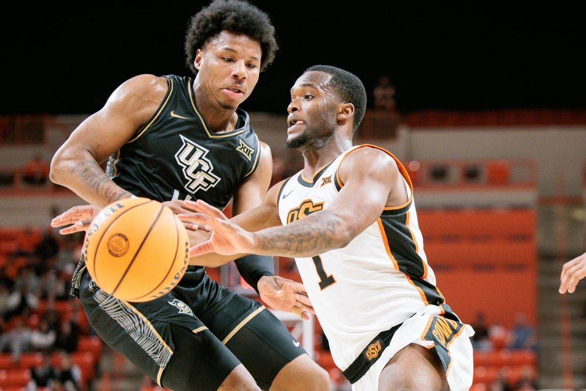 Jan 6, 2026; Stillwater, Oklahoma, USA; Oklahoma State Cowboys guard Kanye Clary (1) drives to the basket around UCF Knights forward Jamichael Stillwell (4) during the first half at Gallagher-Iba Arena. Mandatory Credit: William Purnell-Imagn Images