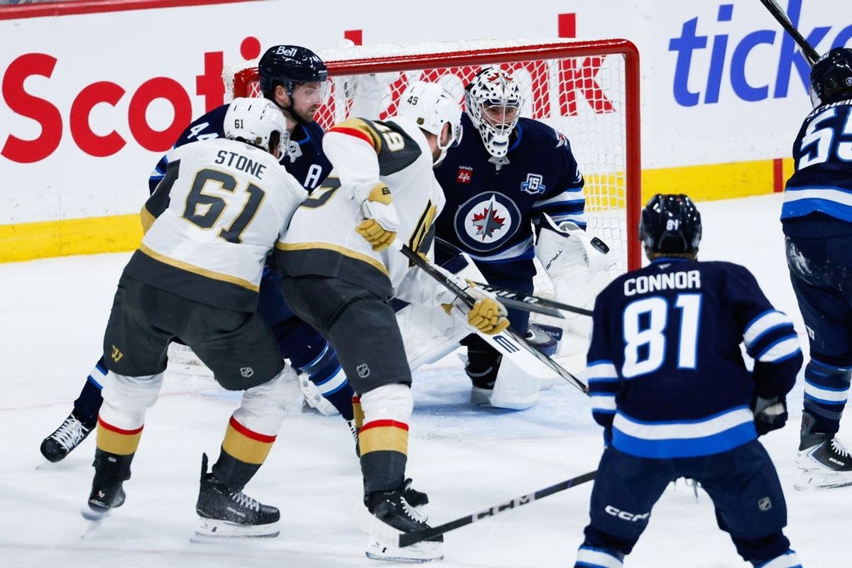 Jan 6, 2026; Winnipeg, Manitoba, CAN;  Winnipeg Jets goalie Connor Hellebuyck (37) and Vegas Golden Knights forward Ivan Barbashev (49) track the puck during the second period at Canada Life Centre. Mandatory Credit: Terrence Lee-Imagn Images