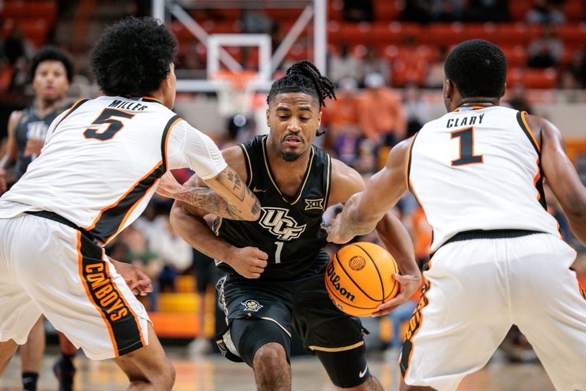 Jan 6, 2026; Stillwater, Oklahoma, USA; UCF Knights guard Themus Fulks (1) drives to the basket between Oklahoma State Cowboys guard Vyctorius Miller (5) and Oklahoma State Cowboys guard Kanye Clary (1) during the second half at Gallagher-Iba Arena. Mandatory Credit: William Purnell-Imagn Images