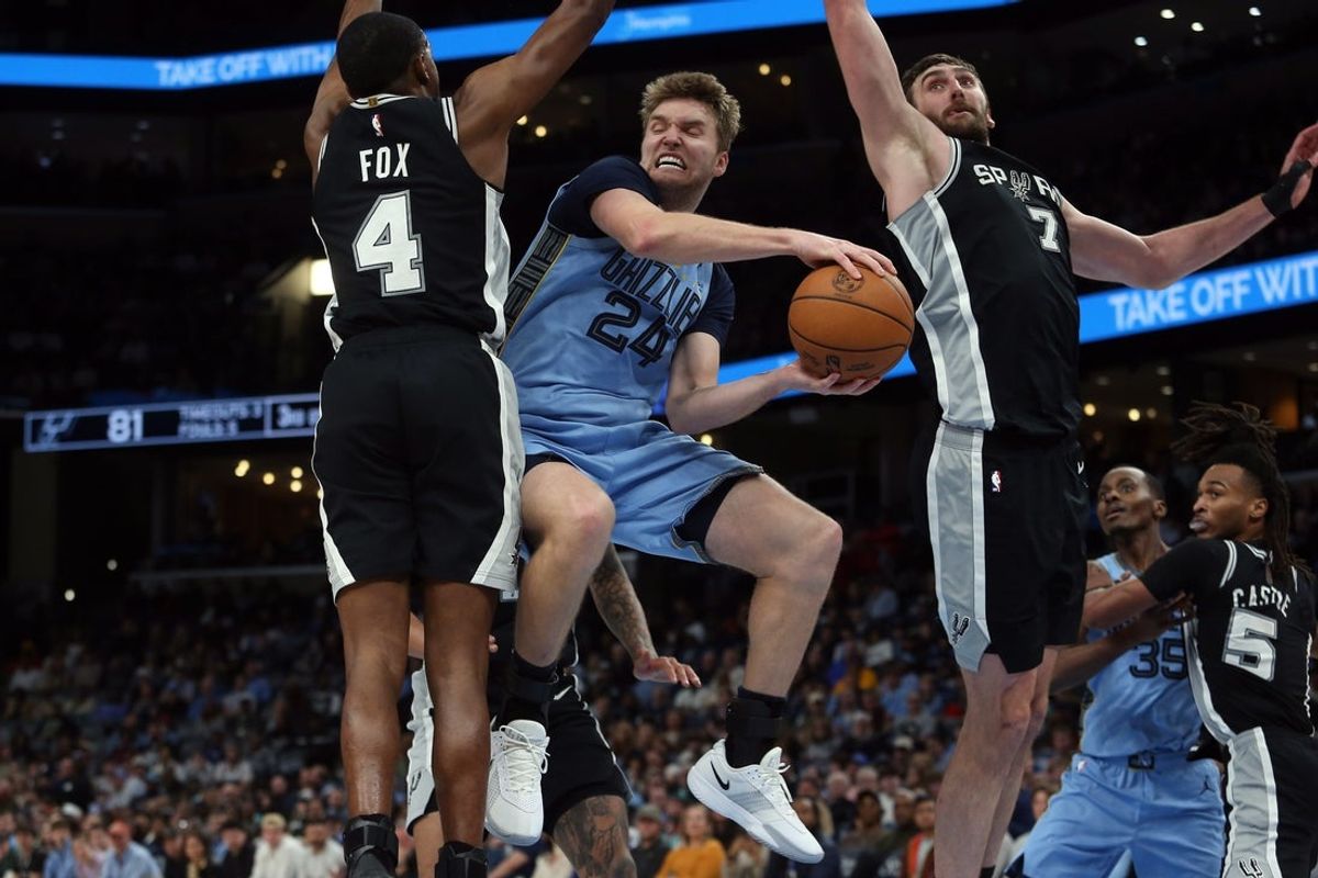 Jan 6, 2026; Memphis, Tennessee, USA; Memphis Grizzlies guard Cam Spencer (24) passes the ball as San Antonio Spurs guard De'Aaron Fox (4) and center Luke Kornet (7) defend during the third quarter at FedExForum. Mandatory Credit: Petre Thomas-Imagn Images