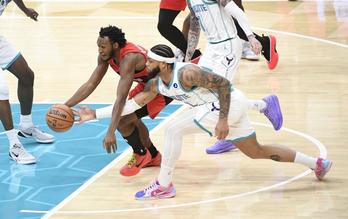 Jan 7, 2026; Charlotte, North Carolina, USA;  Toronto Raptors guard Immanuel Quickley (5) and Charlottte Hornets forward Miles Bridges (0) go after a loose ball during the first half at the Spectrum Center. Mandatory Credit: Sam Sharpe-Imagn Images