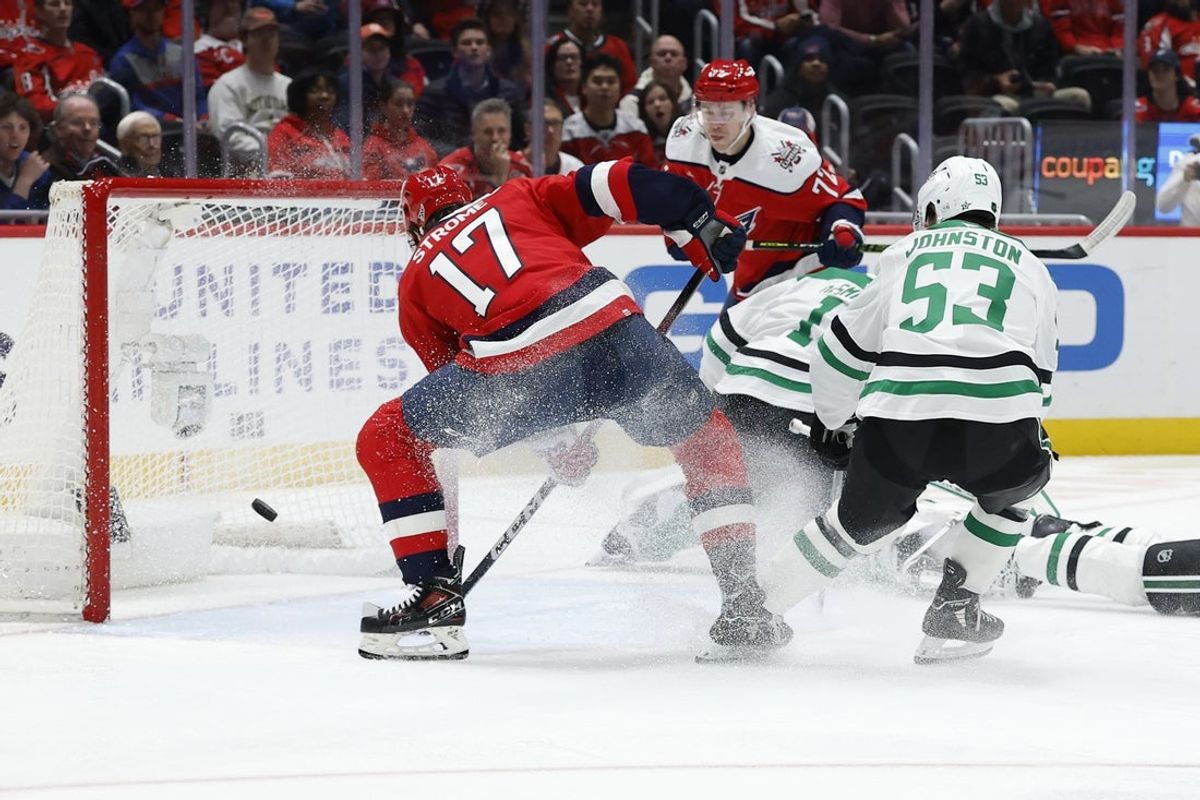 Jan 7, 2026; Washington, District of Columbia, USA; Washington Capitals center Dylan Strome (17) attempts to deflect the puck past Dallas Stars goaltender Casey Desmith (1) as Stars center Wyatt Johnston (53) defends during the first period at Capital One Arena. Mandatory Credit: Geoff Burke-Imagn Images