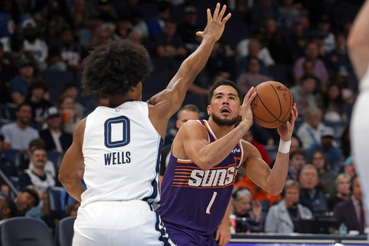 Jan 7, 2026; Memphis, Tennessee, USA; Phoenix Suns guard Devin Booker (1) shoots as Memphis Grizzlies forward Jaylen Wells (0) defends during the first quarter at FedExForum. Mandatory Credit: Petre Thomas-Imagn Images
