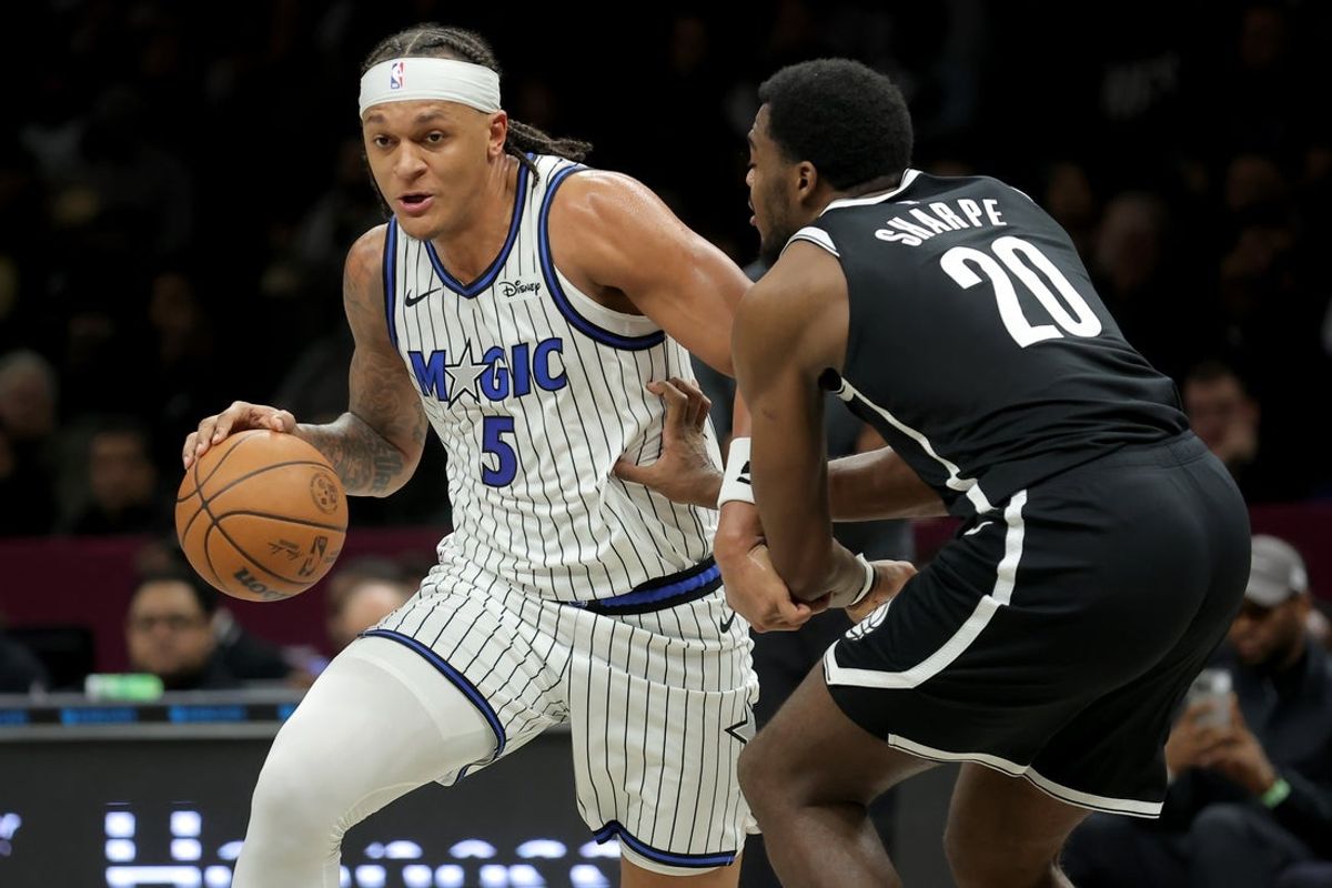 Jan 7, 2026; Brooklyn, New York, USA; Orlando Magic forward Paolo Banchero (5) drives to the basket against Brooklyn Nets center Day'ron Sharpe (20) during the second quarter at Barclays Center. Mandatory Credit: Brad Penner-Imagn Images