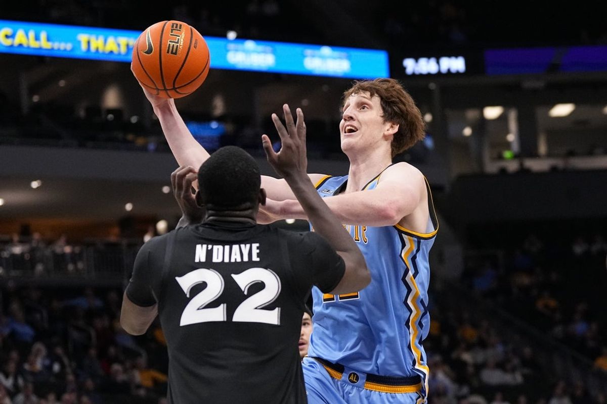 Jan 7, 2026; Milwaukee, Wisconsin, USA;  Marquette Golden Eagles forward Ben Gold (12) shoots against Xavier Musketeers forward Pape N'Diaye (22) during the second half at Fiserv Forum. Mandatory Credit: Jeff Hanisch-Imagn Images