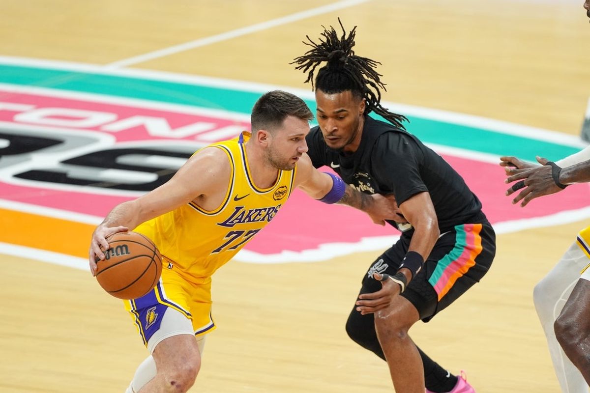 Jan 7, 2026; San Antonio, Texas, USA;  Los Angeles Lakers forward/guard Luka Doncic (77) dribbles against San Antonio Spurs guard Stephon Castle (5) in the first half at Frost Bank Center. Mandatory Credit: Daniel Dunn-Imagn Images