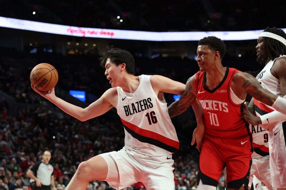 Jan 7, 2026; Portland, Oregon, USA;  Portland Trail Blazers center Yang Hansen (16) grabs a rebound over Houston Rockets forward Jabari Smith Jr. (10) during the first half at Moda Center. Mandatory Credit: Jaime Valdez-Imagn Images