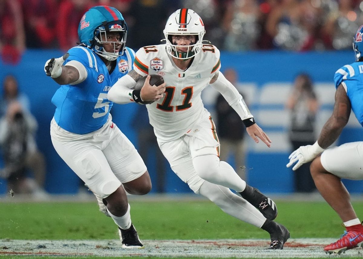 Miami Hurricanes quarterback Carson Beck (11) scrambles away from Ole Miss Rebels defensive end Kam Franklin (5) during their Vrbo Fiesta Bowl matchup at State Farm Stadium in Glendale, on Jan. 8, 2026.