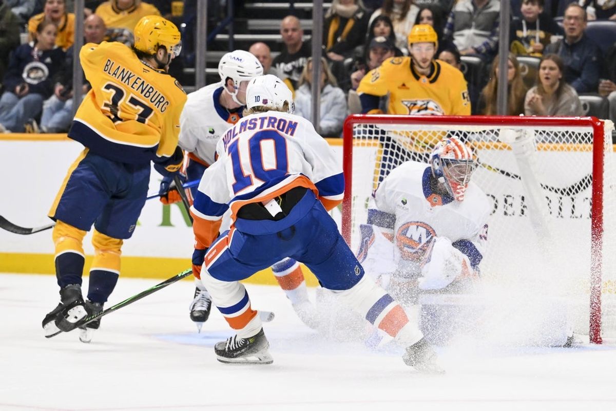 Jan 8, 2026; Nashville, Tennessee, USA; New York Islanders goaltender David Rittich (33) blocks the shot of Nashville Predators defenseman Nick Blankenburg (37) during the first period at Bridgestone Arena. Mandatory Credit: Steve Roberts-Imagn Images