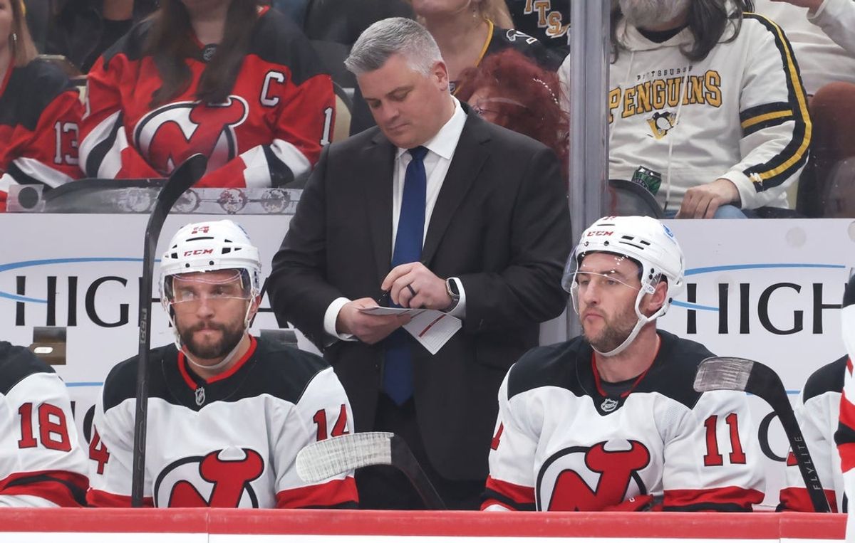 Jan 8, 2026; Pittsburgh, Pennsylvania, USA;  New Jersey Devils head coach Sheldon Keefe makes a note on the bench against the Pittsburgh Penguins during the first period at PPG Paints Arena. Mandatory Credit: Charles LeClaire-Imagn Images