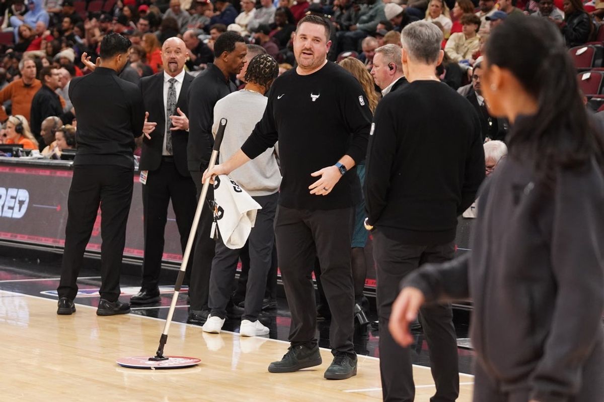 Jan 8, 2026; Chicago, Illinois, USA; A United Center employee mops the court. The game between the Chicago Bulls and the Miami Heat is delayed because of condensation on the floor due to rain and humidity at United Center. Mandatory Credit: David Banks-Imagn Images