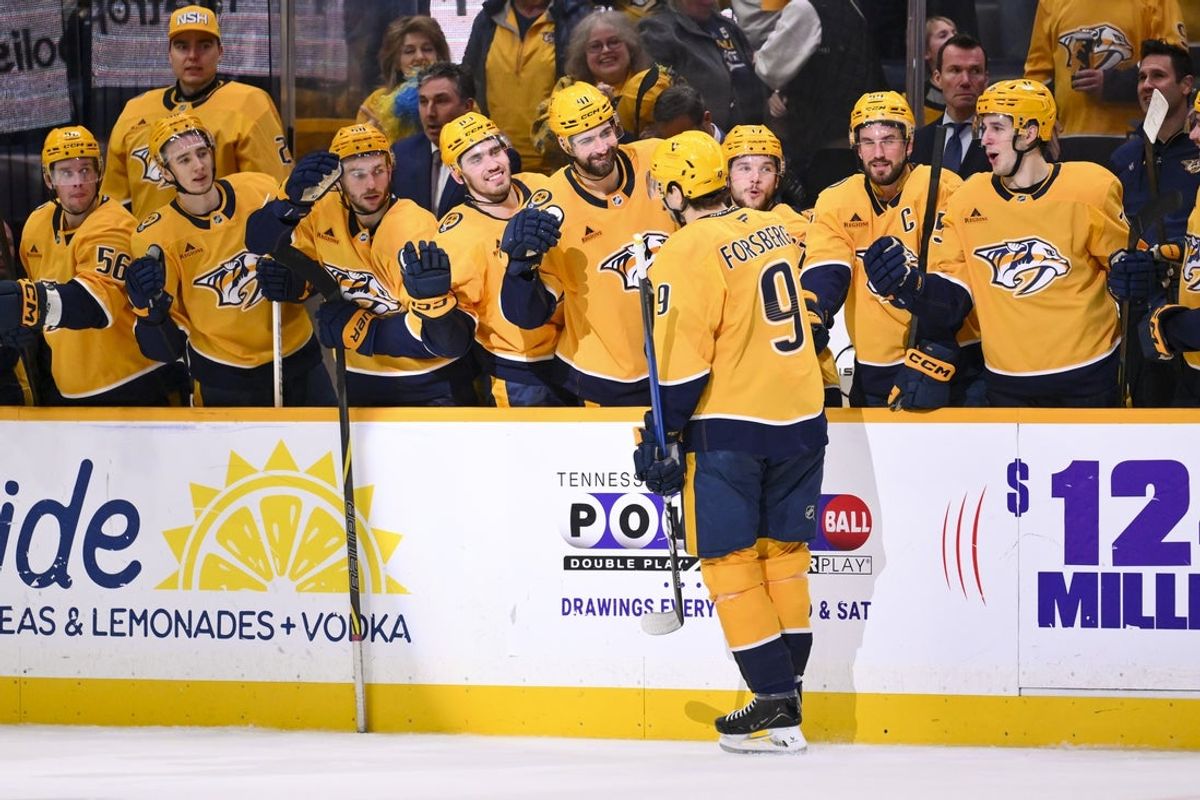 Jan 8, 2026; Nashville, Tennessee, USA; Nashville Predators left wing Filip Forsberg (9) celebrates with his teammates after scoring a goal during the shootout period against the New York Islanders at Bridgestone Arena. Mandatory Credit: Steve Roberts-Imagn Images