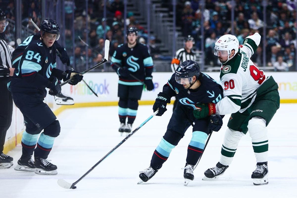 Jan 8, 2026; Seattle, Washington, USA; Seattle Kraken center Matty Beniers (10) and Minnesota Wild left wing Marcus Johansson (90) battle for the puck in the second period at Climate Pledge Arena. Mandatory Credit: Kevin Ng-Imagn Images