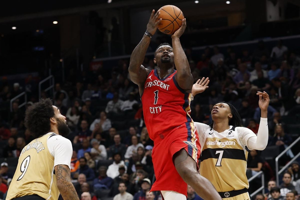 Jan 9, 2026; Washington, District of Columbia, USA; New Orleans Pelicans forward Zion Williamson (1) shoots the ball as Washington Wizards guard Bub Carrington (7) and Wizards forward Justin Champagnie (9) defend in the first quarter at Capital One Arena. Mandatory Credit: Geoff Burke-Imagn Images