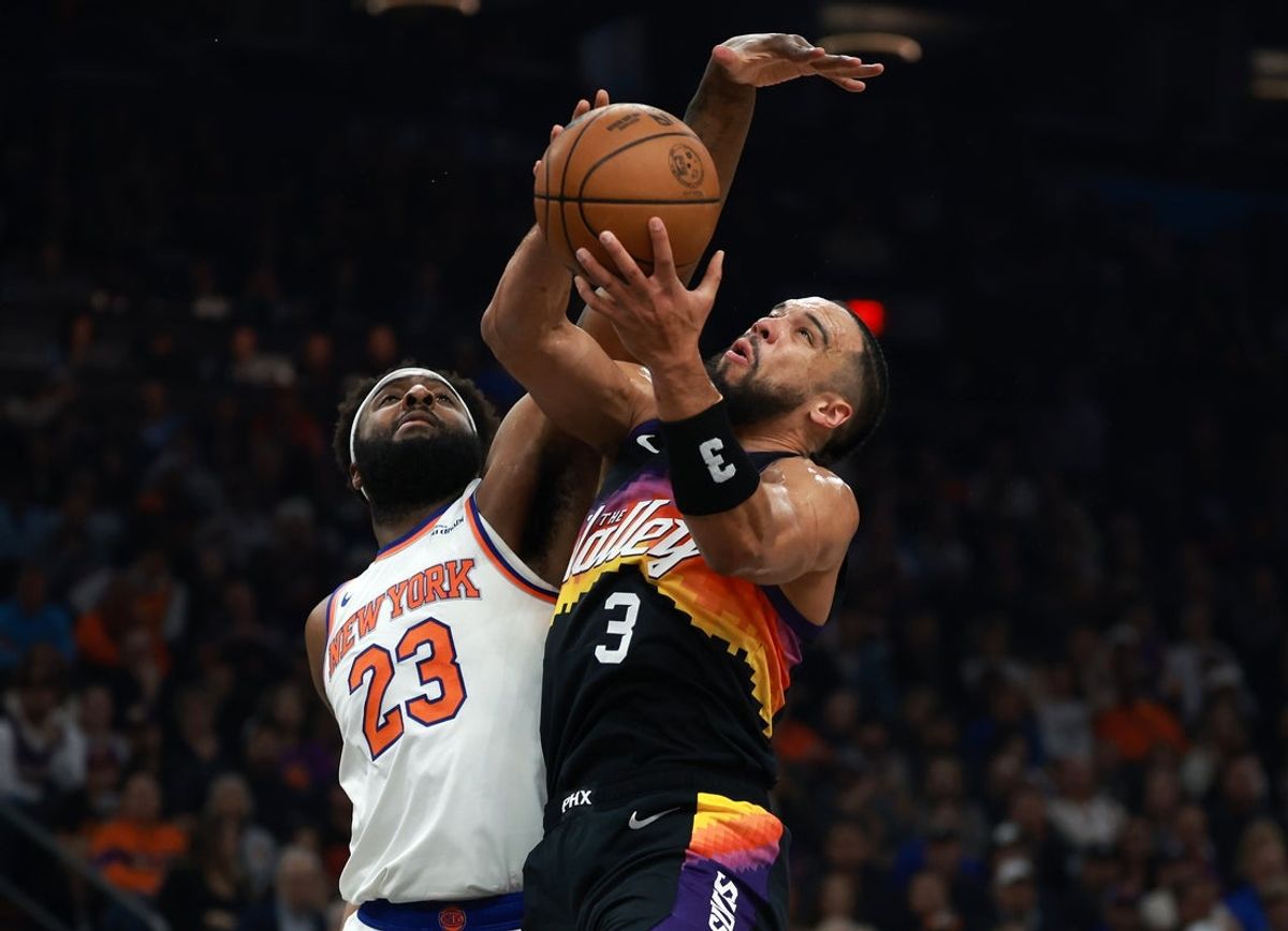 Jan 9, 2026; Phoenix, Arizona, USA; Phoenix Suns forward Dillon Brooks (3) drives to the basket against New York Knicks center Mitchell Robinson (23) in the first half at Mortgage Matchup Center. Mandatory Credit: Mark J. Rebilas-Imagn Images