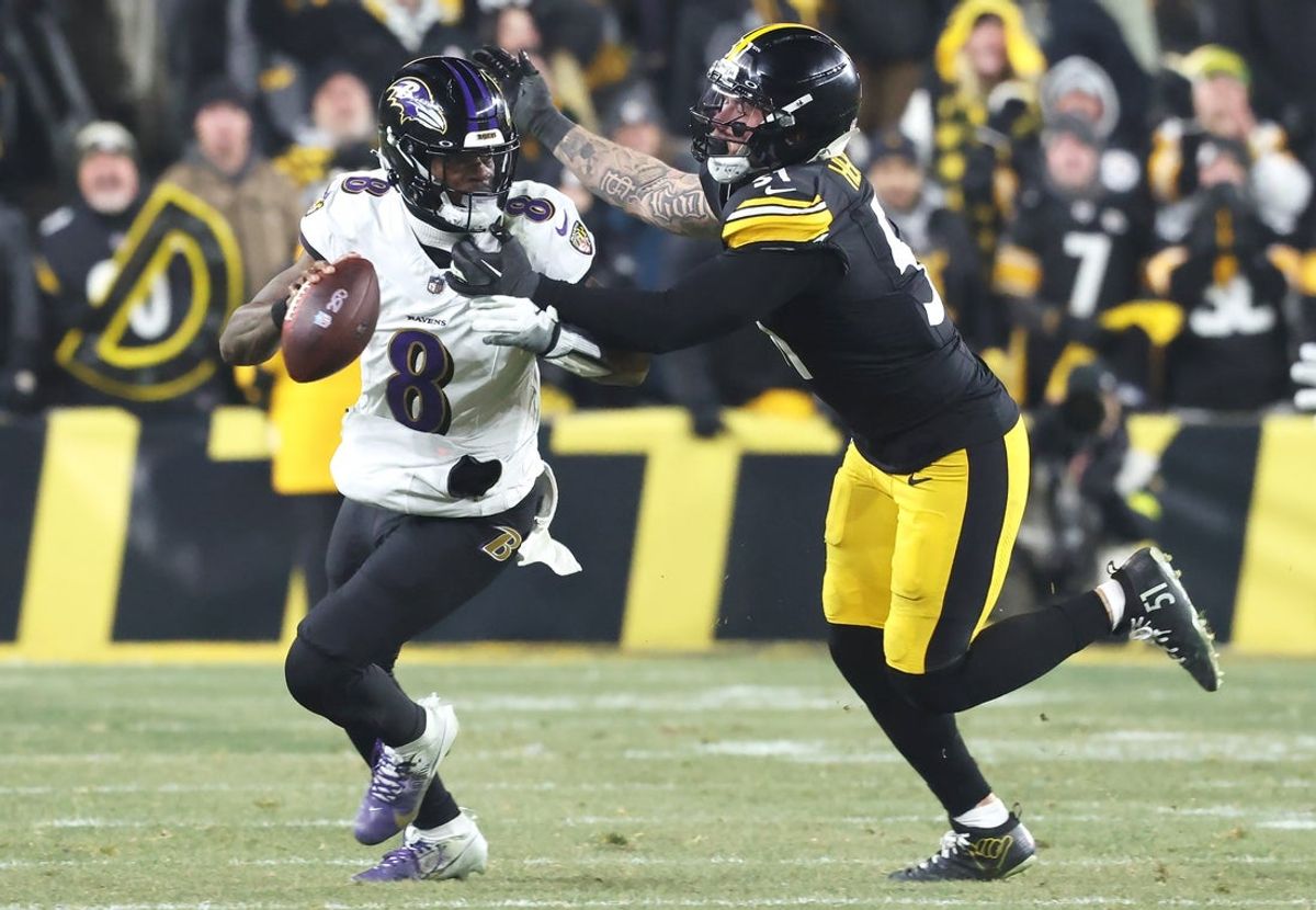 Jan 4, 2026; Pittsburgh, Pennsylvania, USA;  Baltimore Ravens quarterback Lamar Jackson (8) scrambles with the ball as Pittsburgh Steelers linebacker Nick Herbig (51) cases during the fourth quarter at Acrisure Stadium. Mandatory Credit: Charles LeClaire-Imagn Images